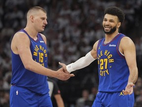 Top Stories Tamfitronics Denver Nuggets centre Nikola Jokic and guard Jamal Murray slap hands.