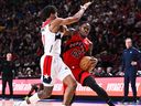 Davion Mitchell #45 of the Toronto Raptors dribbles the ball against Jordan Poole #13 of the Washington Wizards in a pre-season game.