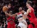 Washington Wizards guard Jordan Poole (13) pushes through Toronto Raptors guard Davion Mitchell (45) and teammate Jakob Poeltl (19) in Montreal on Sunday.