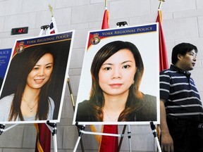 Wei Ruo Zhao (R) passes two pictures of his wife, Fang Lin, during a press conference at York Regional Police headquarters in Aurora, on June 15, 2011. The 40-year-old Markham women who was known to be a gambler and money lender has been missing since April 21, 2011. (Postmedia file photo)