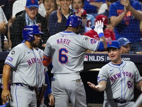 Mets' Starling Marte (6) celebrates after hitting an RBI sacrifice fly against the Phillies with manager Carlos Mendoza (right) during the eighth inning of Game 1 of their NL Division Series in Philadelphia, Saturday, Oct. 5, 2024.