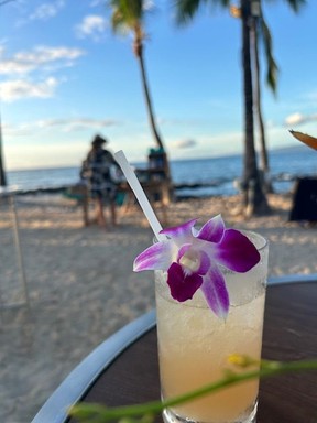 A Mai Tai by the beach at sunset