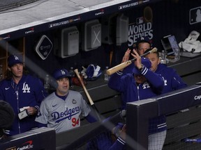 Major League Field Coordinator Bob Geren #88 of the Los Angeles Dodgers catches a bat from Anthony Volpe #11 of the New York Yankees in the seventh inning during Game Three of the 2024 World Series at Yankee Stadium on October 28, 2024 in the Bronx borough of New York City.