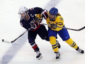 Pernilla Winberg of Sweden charges Natalie Darwitz of the United States during a game at the 2010 Winter Olympics.