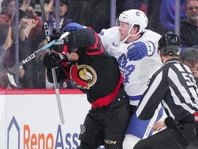 Morgan Rielly cross-checks Ridly Greig