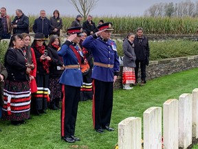 Corps Sgt.-Maj. Christa Laforce and her husband Deputy Chief Devin Laforce, of the Edmonton Police Service, pay their respects at the grave of Alex Decoteau in Passchendaele New British Cemetery in Zonnebeke, Belgium, on Indigenous Veterans Day on Friday, Nov. 8, 2024.