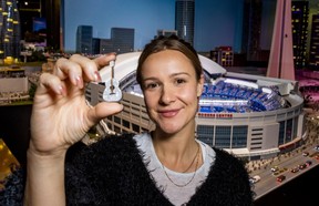 With a miniature version of the Rogers Centre behind her, Camille Wodka, campaign producer with Little Canada, holds an Eras-themed Taylor Swift inspired guitar at a display on Little Canada in downtown Toronto on Friday, Nov. 22, 2024.
