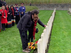 Rick Decoteau, the great-nephew of Alex Decoteau, and his wife Melinda leave an offering of tobacco at the grave of his ancestor, a Cree man who was killed during the First World War, at the Passchendaele New British Cemetery in Zonnebeke, Belgium, on Indigenous Veterans Day on Friday, Nov. 8, 2024.