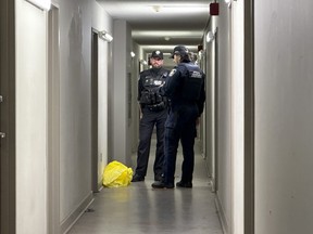 Toronto Police and TCHC officers stand in the hallway of an apartment building in West Hill where a man was fatally stabbed, Thursday, Nov. 7, 2024.