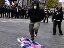 A man dances on the Israeli flag as students gather outside Concordia University to protest against the continuing conflict in Gaza. The students are seen in Montreal on Thursday, Nov. 21, 2024.