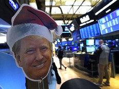 An image of U.S. President-elect Donald Trump is displayed as traders and financial professionals work on the floor of the New York Stock Exchange (NYSE) at the opening bell on November 26, 2024, in New York City.