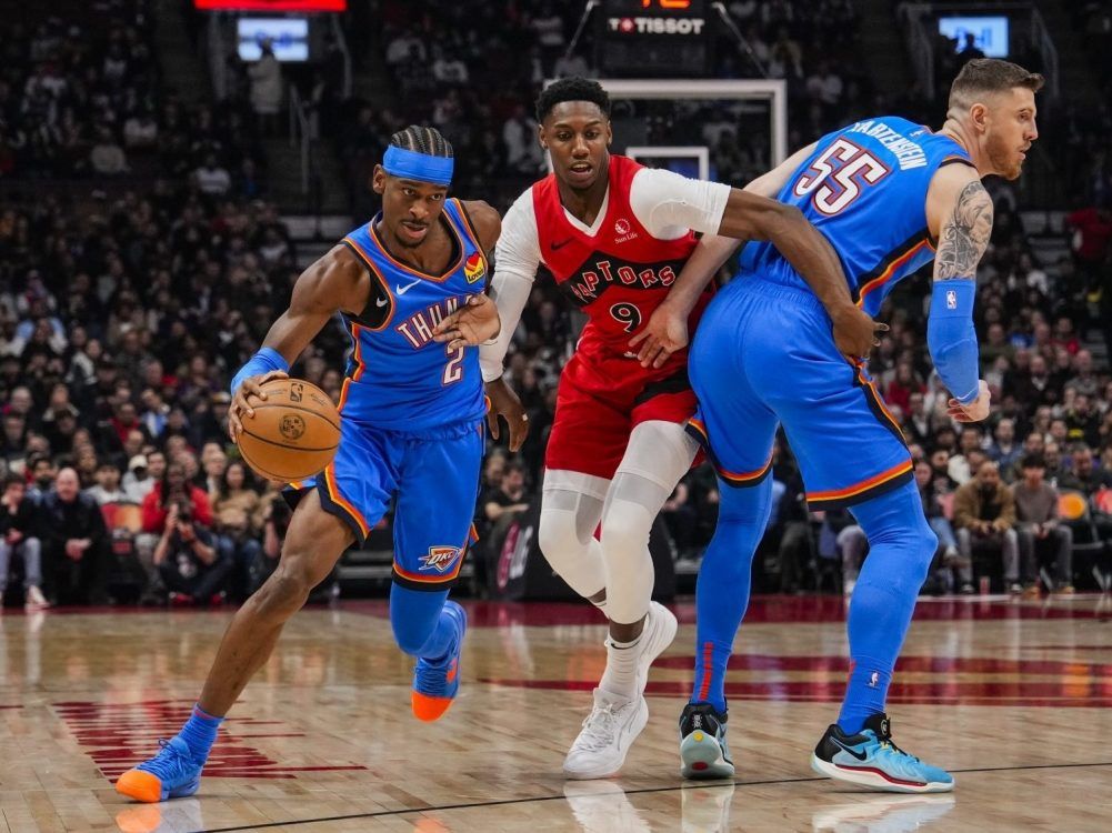 Shai Gilgeous-Alexander of the Oklahoma City Thunder drives to the basket as teammate Isaiah Hartenstein sets a pick on RJ Barrett of the Toronto Raptors at Scotiabank Arena on Dec. 5, 2024 in Toronto.
