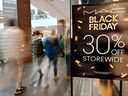 Shoppers walk past a Black Friday sale banner at a store in a mall in Arlington, Va., on Nov. 29, 2024.