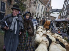 People in costumes from Charles Dickens' 19th-century English era take part in a Dickens Festival, in Deventer, Netherlands, Saturday, Dec. 14, 2024.