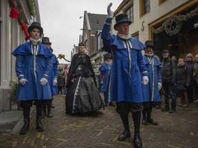 Sandra Nieland plays Queen Victoria a people in costumes from Charles Dickens' 19th-century English era take part in a Dickens Festival, in Deventer, Netherlands, Saturday, Dec. 14, 2024.