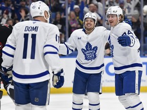 Maple Leafs forward Bobby McMann, right, celebrates with Nicholas Robertson, centre, and Max Domi (11) after scoring during the first period against the Sabres in Buffalo, N.Y., Friday, Dec. 20, 2024.