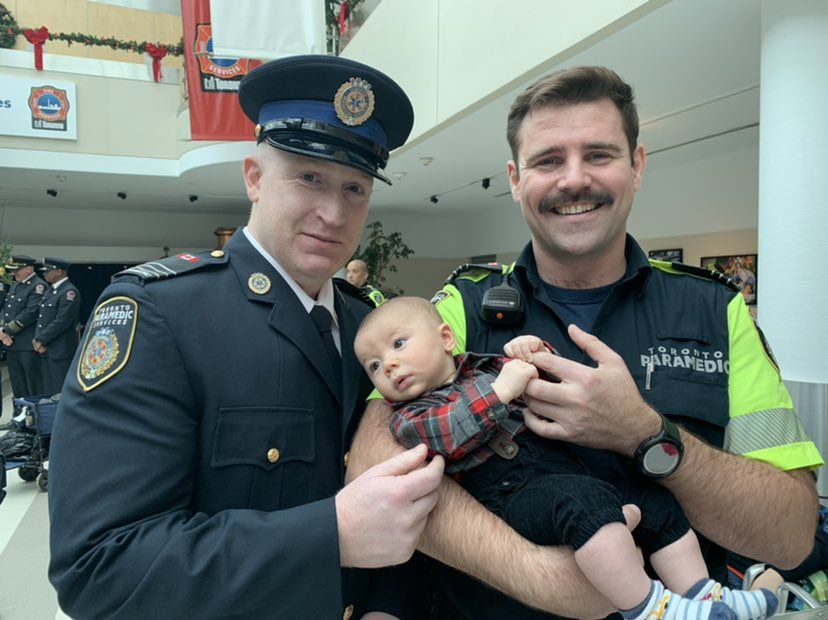 toronto paramedics scott bryant (left) and jacob pettigrew (right) reunited on thursday with four- month-old baby boy, nikko takahashi, who they helped deliver in a hospital elevator.