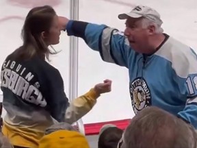 An older man argues with a mother at a Pittsburgh Penguins game.
