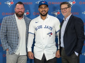 From left: Toronto Blue Jays manager John Schneider, Anthony Santander and GM Ross Atkins pose for a photo.
