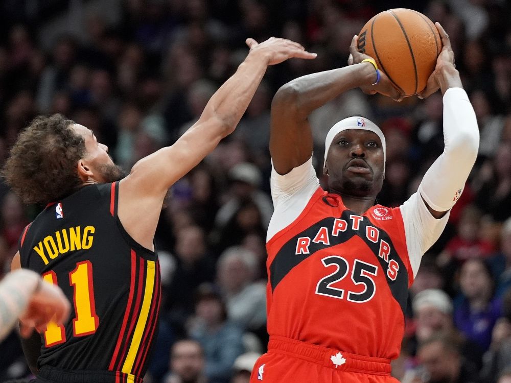 El alero de los violadores de Toronto, Chris Boucher (25), ha hecho un disparo de tres puntos bajo la presión del guardia de los Atlanta Hawks Young.