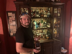 The Botanist's Pete Kyle shows off one of the about 100 different kinds of whisky that he offers at tastings in the basement of his restaurant. (Jane Stevenson/Toronto Sun)