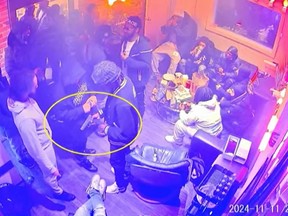 This screengrab from Toronto Police released Thursday, Jan. 23, 2025, shows a group of individuals holding firearms during a party in downtown Toronto on Nov. 11, 2024.