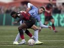 بيك راي إينورو لاعب تامورث، على اليسار، وبيدرو بورو لاعب توتنهام هوتسبير يتصارعان على الكرة خلال مباراة الدور الثالث لكأس الاتحاد الإنجليزي على ملعب لامب جراوند، تامورث، إنجلترا، الأحد 12 يناير 2025.