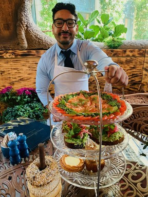 Server Michael Villalvazo arrives at the private table with Sadelle’s signature Salmon Tower, featuring layers of exquisite smoked salmon and capers, fresh tomatoes, cucumber slices and refreshing avocado toast on sourdough.