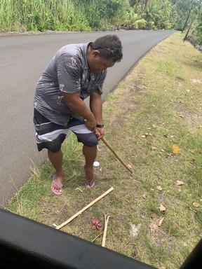Yvann Mama prepares a hibiscus branch to make a flute