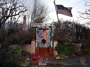 A U.S. flag and Christmas decorations are seen on the remains of a home after the passage of the Palisades Fire in Pacific Palisades, Calif., on Jan. 8, 2025.