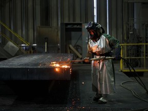 An employee performs a quality check on a steel slab at the Stelco Holdings Inc. plant in Nanticoke, Ont., on Tuesday, Nov. 14, 2017.