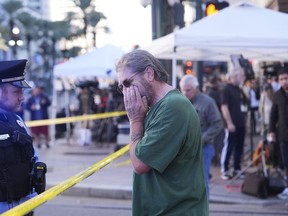 Edward Bruski, center, gets emotional at the scene where a vehicle drove into a crowd on New Orleans' Canal and Bourbon Street, Wednesday Jan. 1, 2025.