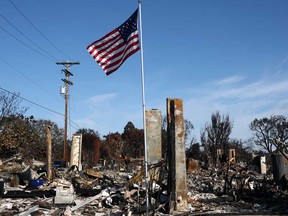 Una bandera estadounidense voló sobre los restos de una casa que se incendió en Palcade el 26 de enero de 2021 en California, California.
