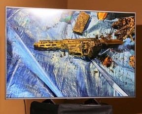 A monitor displays an image of a burned semiautomatic firearm recovered from a Tesla Cybertruck that exploded on New Year's Day in front of the entrance to the Trump International Hotel & Tower Las Vegas during a news conference at Las Vegas Metropolitan Police Department headquarters on Jan. 2, 2025 in Las Vegas, Nevada.