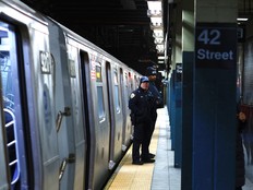 Members of the NYPD stand in a subway station