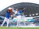 Danny Jansen of the Toronto Blue Jays is doused with water by Vladimir Guerrero Jr. following a game against the Chicago White Sox at Rogers Centre.