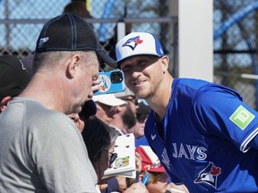 Toronto Blue Jays pitcher Jeff Hoffman poses for a photograph and signs autographs for fans during spring training.