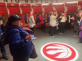 Fans take in the Raptors locker room during a tour of Scotiabank Arena.