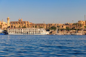A cruise ship passes Luxor Temple on the east bank of the Nile river in Luxor.