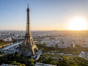 Aerial view of Paris, France, overlooking the famous Eiffel Tower, sunrise in the background.