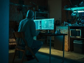 Home Garage في وقت متأخر من الليل: يقتحم القراصنة الذكور الشرير الذي يرتدي أغطية خوادم البيانات ، وهجوم DDOs ، وهجوم التصيد ، والبرنامج الضار. الرجل الذي يكتب رمز لفيروس حصان طروادة. مفهوم Darknet من الجريمة السيبرانية.