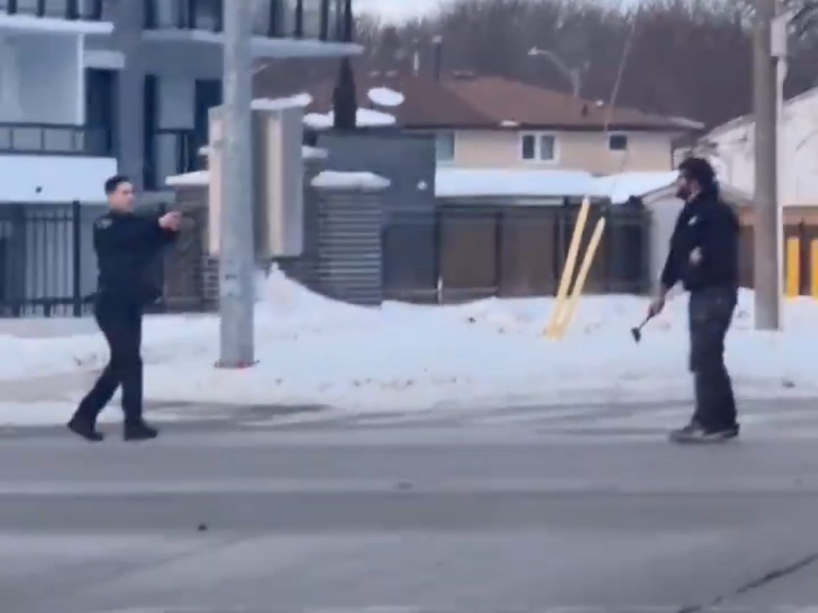 Un oficial del Servicio de Policía Regional de Waterloo se enfrenta a un hombre con una escotilla en la cocina el miércoles 7 de febrero de 2021.