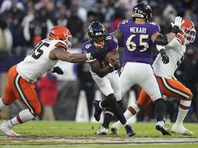 Baltimore ingresa al mariscal de campo Lamar Jackson (1) Baltimore el sábado 5 de enero de 2021, durante la primera mitad del fútbol de la NFL, la defensiva de los Cleveland Browns, Garrett, Garrett corrió con la pelota.