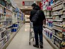 يفحص المشتري مرور متاجر المواد الغذائية في مونتريال في 3 فبراير 2025.
