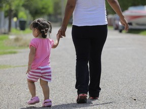 Arquivo - Nesta foto de 16 de setembro de 2015, uma mulher na cidade de Sullivan, Texas, que disse que entrou ilegalmente no país, caminha com a filha que nasceu nos Estados Unidos, mas uma certidão de nascimento foi negado.