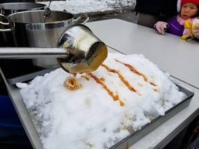 El bebé vertió la nieve con el jarabe de arce.