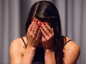 A girl crying into her hands.