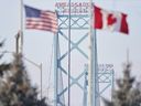 The American and Canadian flags fly at the Ambassador Bridge border crossing in Windsor, Ont., on Feb. 9, 2022.