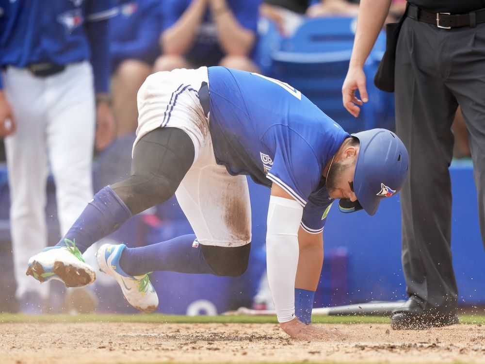 Toronto Blue Jays shortstop Bo Bichette slides safe at home plate to score a run against the New York Yankees during third inning Grapefruit League MLB baseball action in Dunedin Fla., Saturday, Feb. 22, 2025.