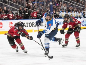 Toronto Sceptres' Hannah Miller (34) takes the shot as Ottawa Charge's Taylor House (22) tries to stop her during third period PWHL action in Edmonton, Sunday, Feb. 16, 2025.